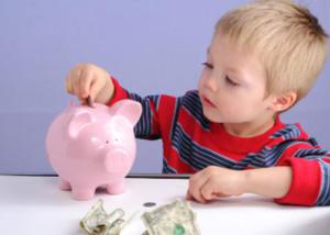 Kid putting money into a piggy bank